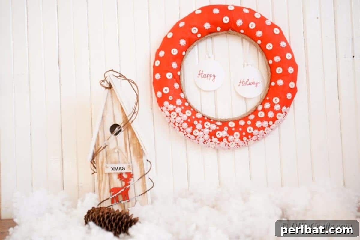 Christmas button wreath hanging elegantly next to a decorative holiday item