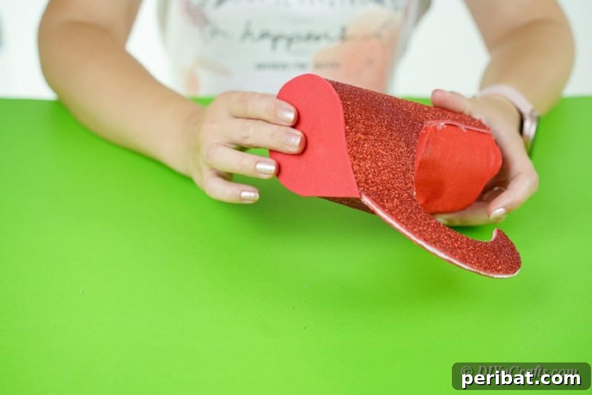 Upcycled Plastic Bottle Santa Boot Decor 13 Securing a piece of foam paper onto the bottom of the bottle and boot to form a stable base
