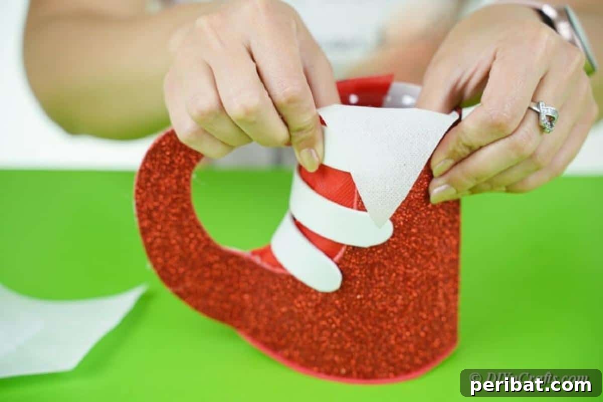 Upcycled Plastic Bottle Santa Boot Decor 15 Gluing a triangular piece of white paper onto the top interior of the foam craft boot