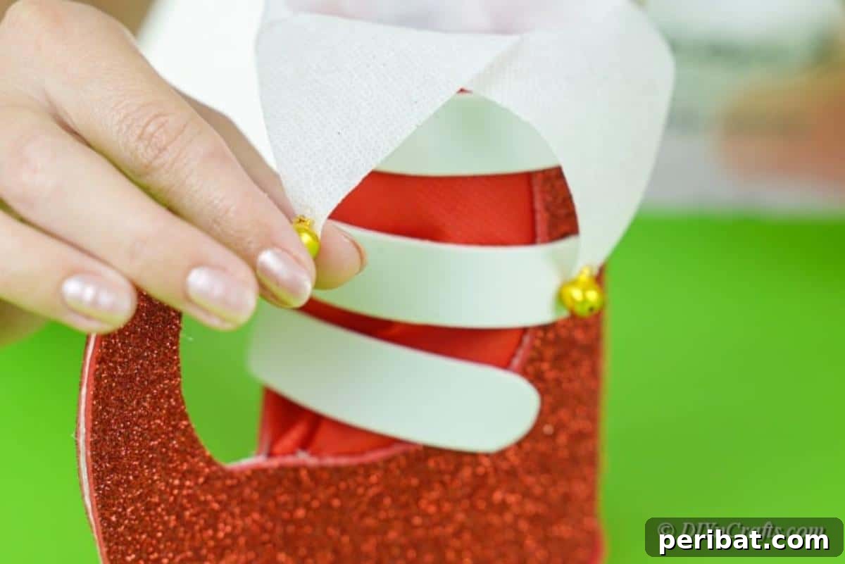Upcycled Plastic Bottle Santa Boot Decor 16 Adding decorative craft bells to the ends of the white paper triangles on the Santa boot