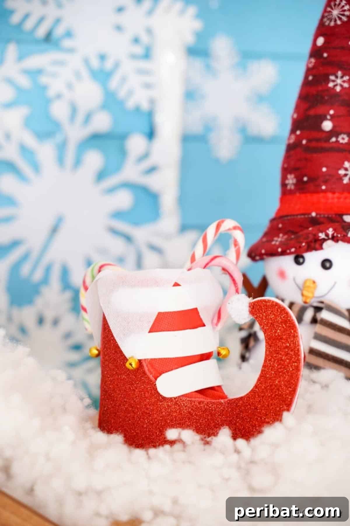 Upcycled Plastic Bottle Santa Boot Decor 3 Handmade Santa boot craft centerpiece nestled in a vibrant Christmas display, surrounded by lights and ornaments