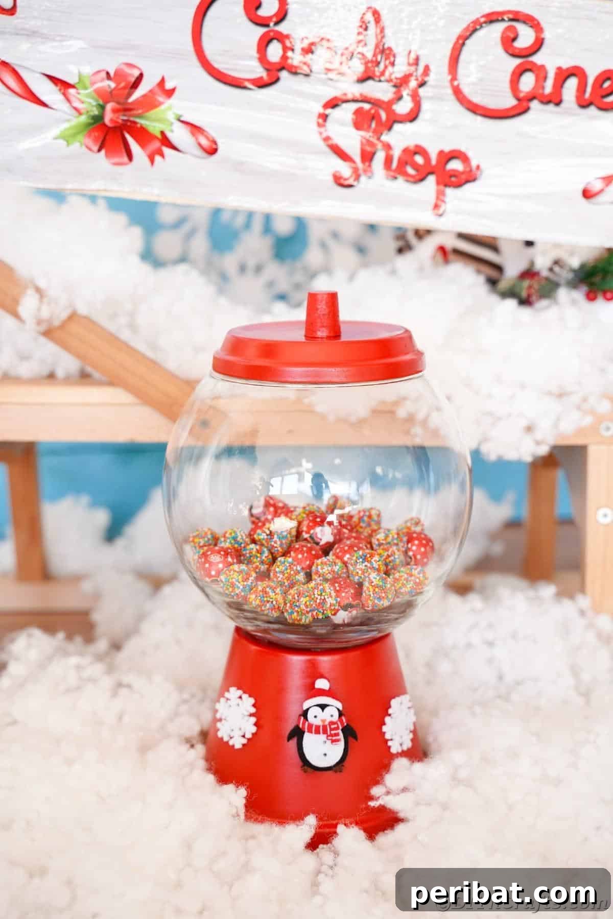 Festive Candy Dispenser on a Budget 5 red candy jar on fake snow with candy cane shop sign in background