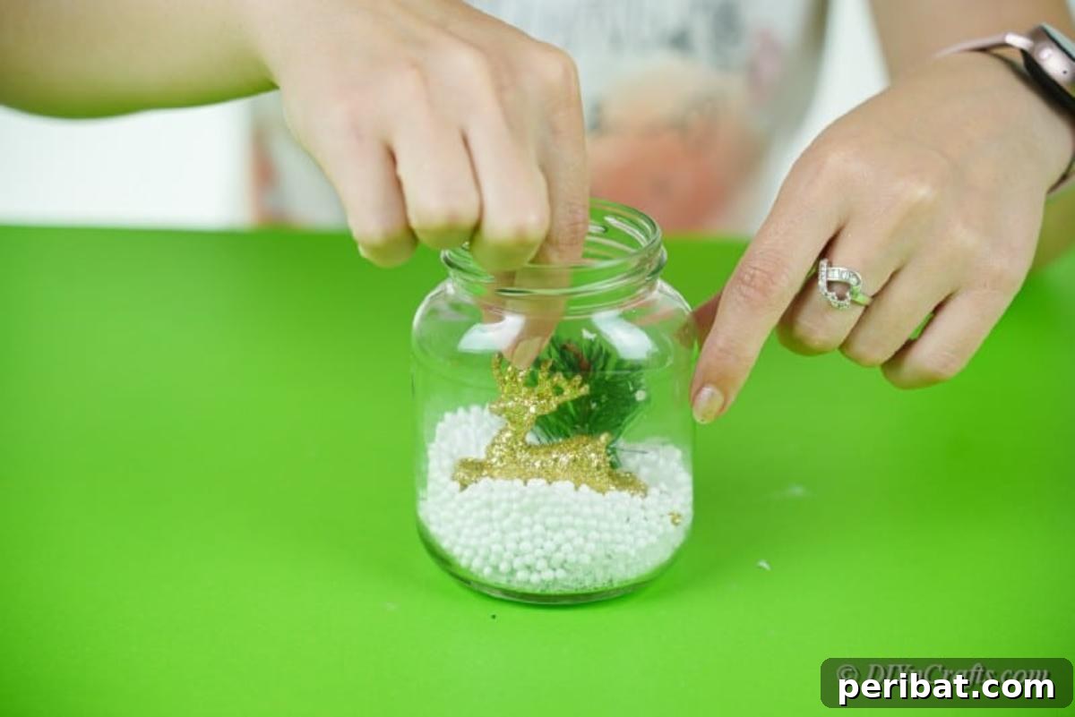 DIY Upcycled Christmas Snow Globe 13 filling a jar with dacorative pieces