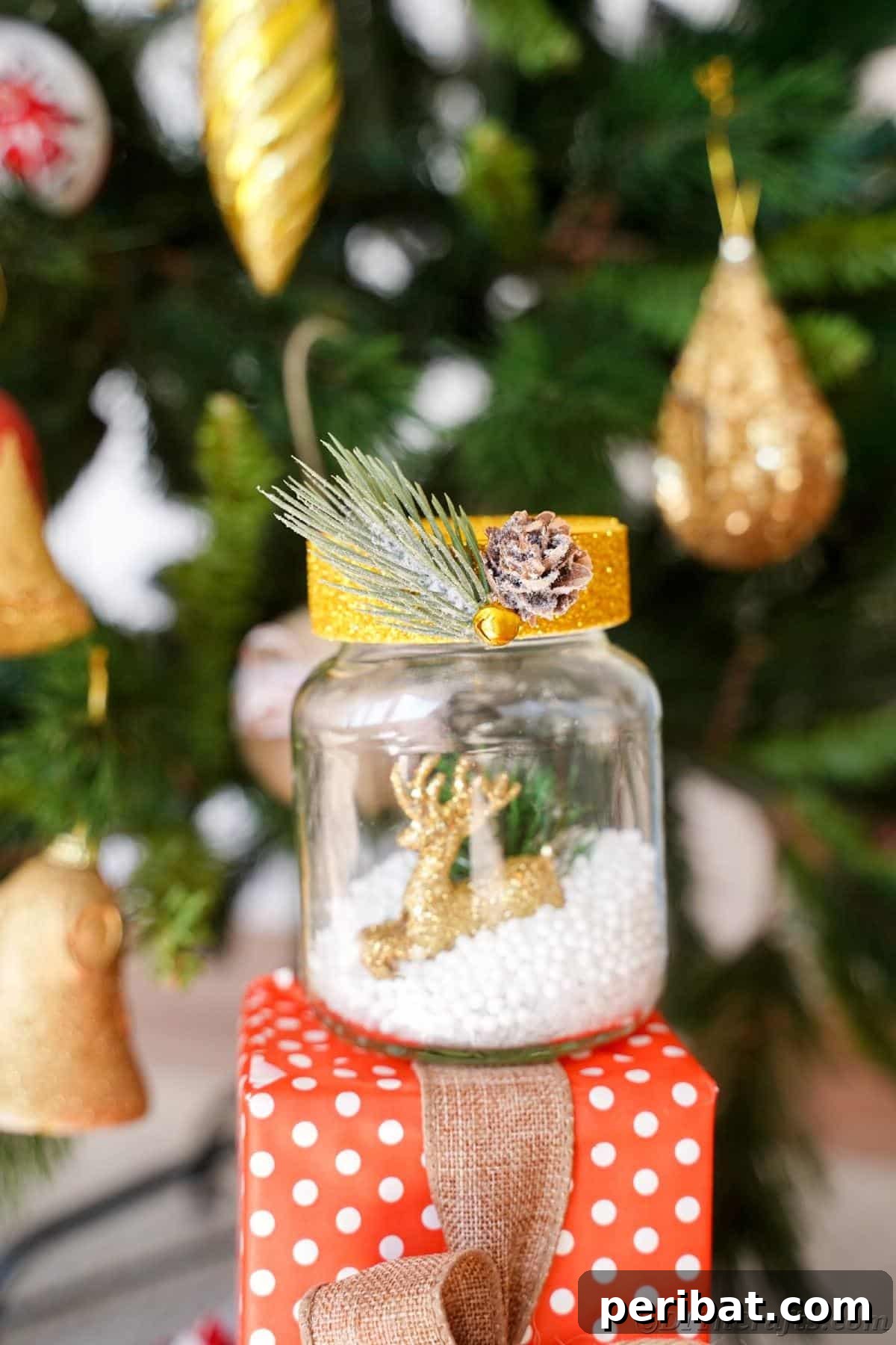 DIY Upcycled Christmas Snow Globe 17 snow globe with gold top on red and white gift by tree