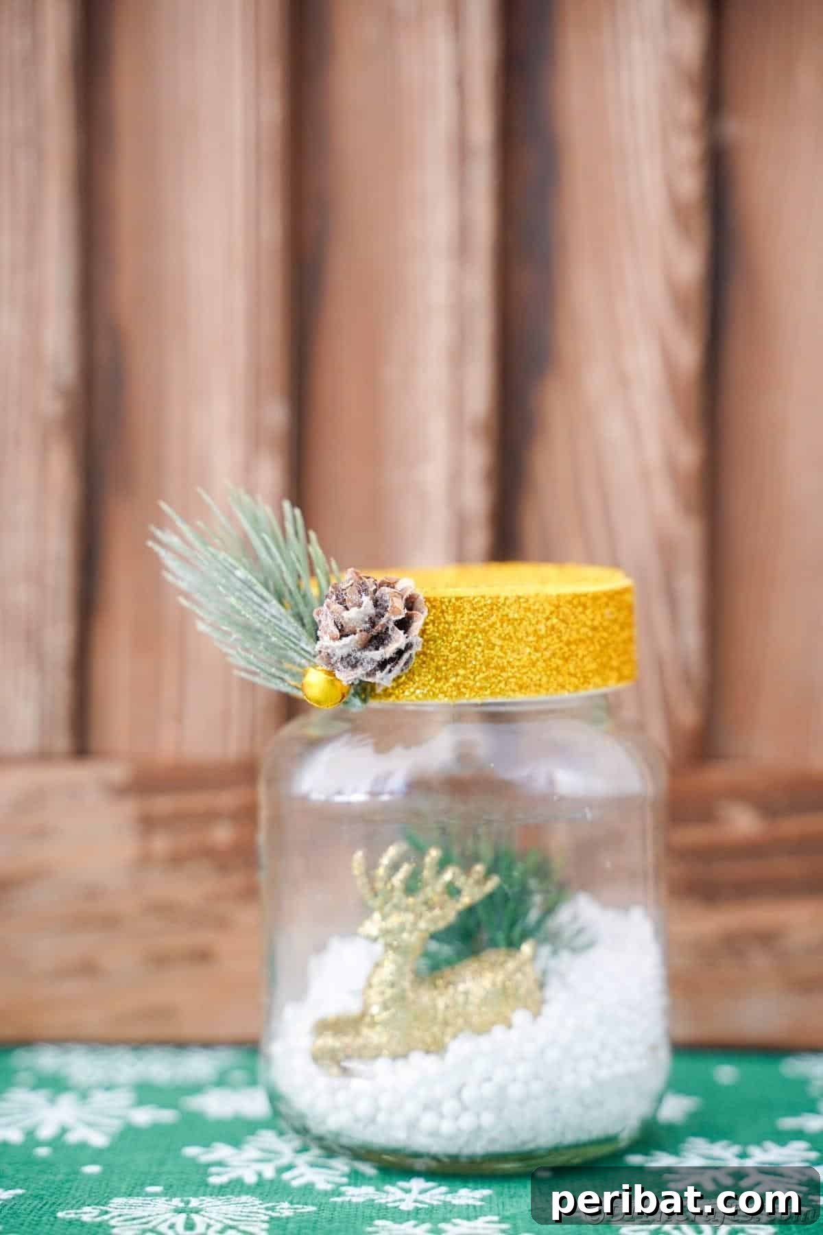 DIY Upcycled Christmas Snow Globe 6 snow globe with gold top on green snowflake paper by wood background