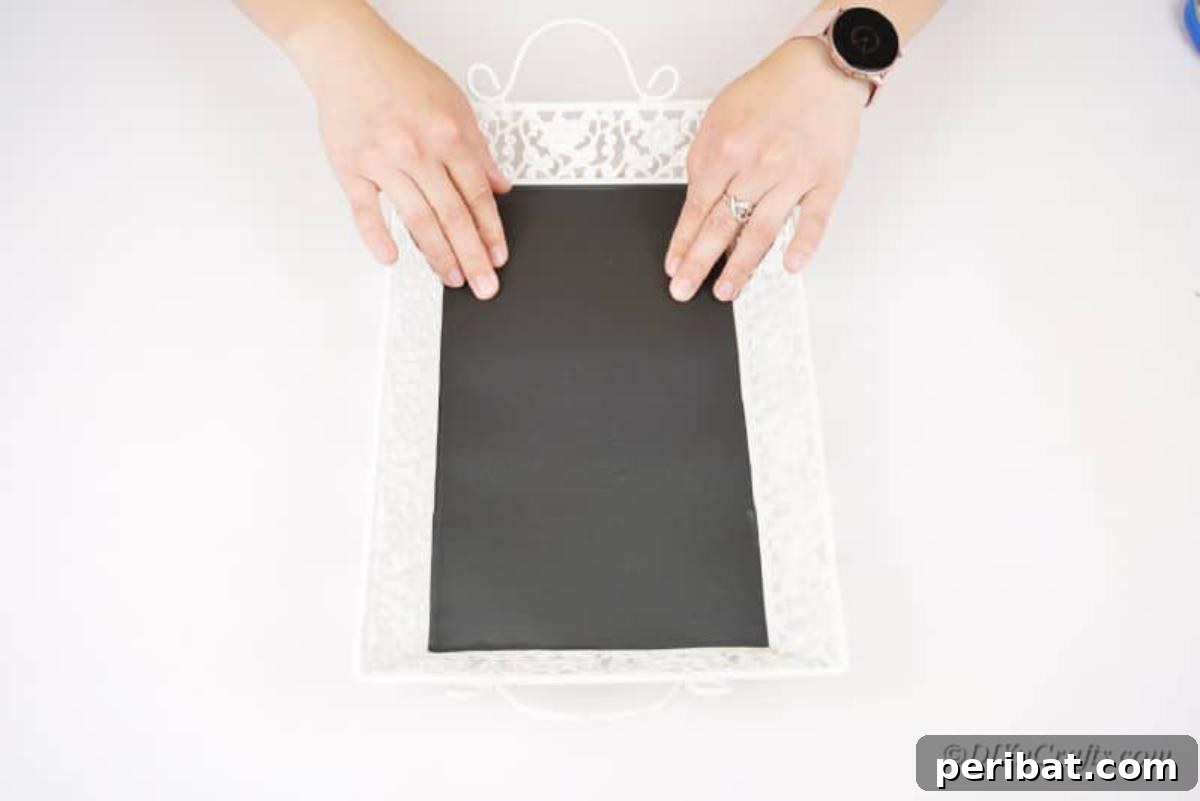 applying adhesive chalkboard sheet to tray