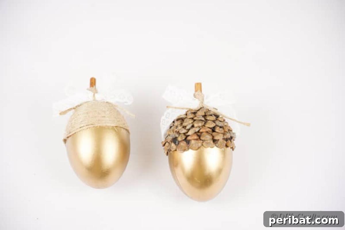 Atık Plastik Yumurtalardan Sonbahar Meşe Palamudu Yapımı 16 Two completed golden egg crafts, transformed into elegant decorative acorns, ready for display.
