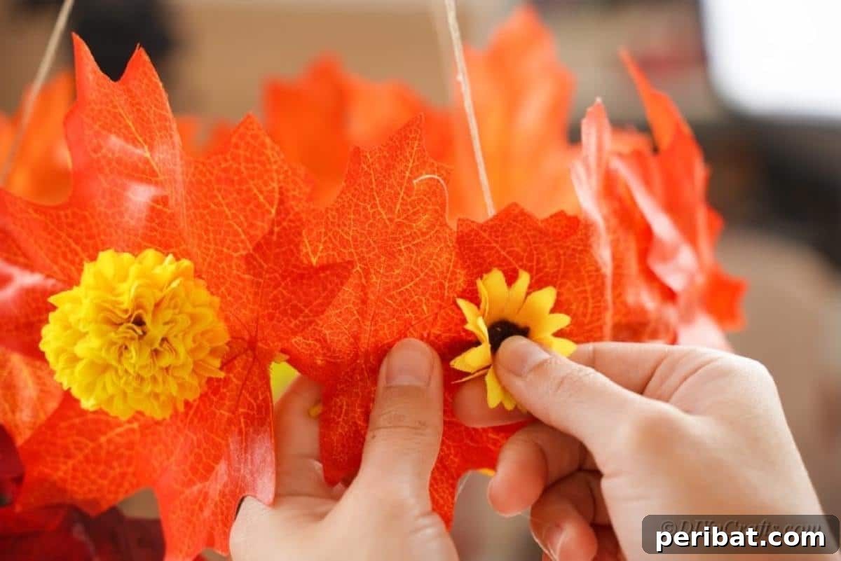 Vibrant Autumn Leaves Mobile 12 Hand pressing fake sunflower into oraneg leaf