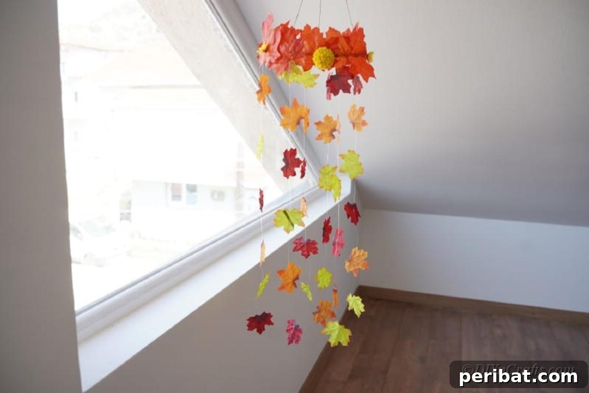 Vibrant Autumn Leaves Mobile 5 Mobile made of artificial leaves hanging by large window against white wall