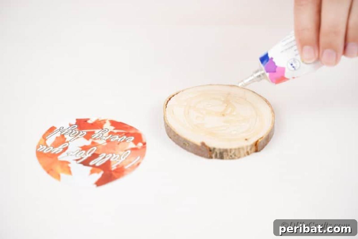 Autumnal Wood Slice Photo Keepsakes 11 Hand holding glue above wood slice with fall picture on table