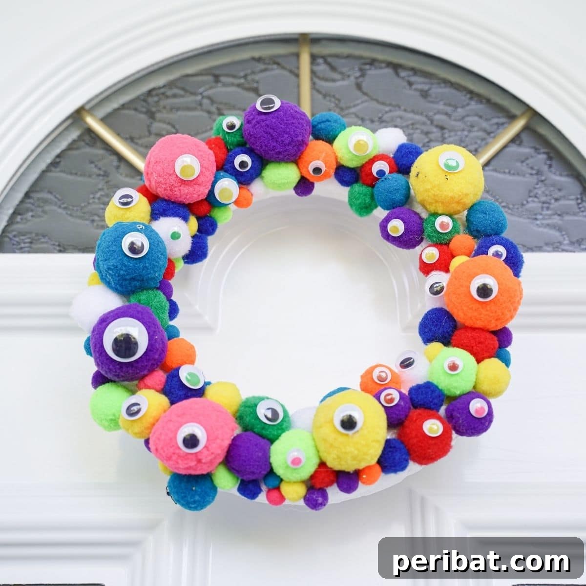 Creepy Cute Pom Pom Monster Wreath 2 Colorful monster eye wreath on white front door