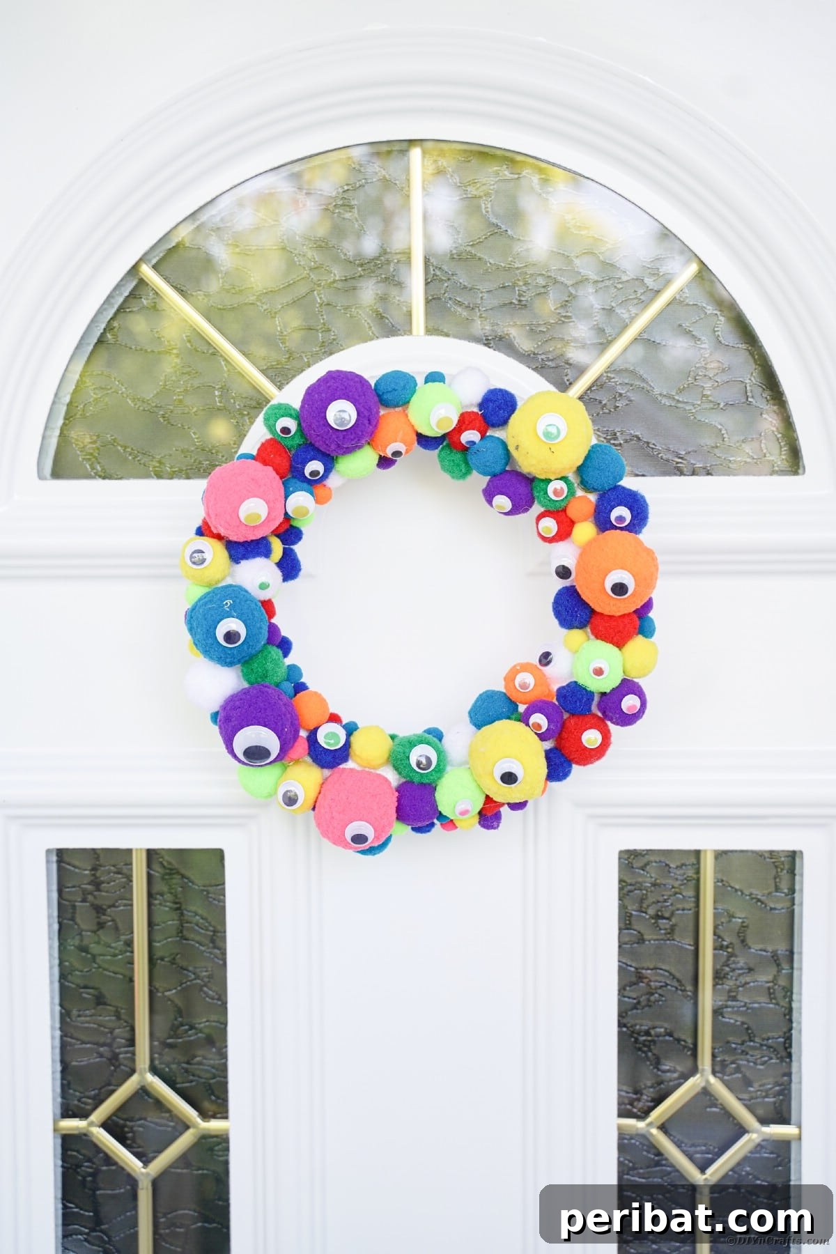 Creepy Cute Pom Pom Monster Wreath 9 Colorful monster eye wreath on white front door