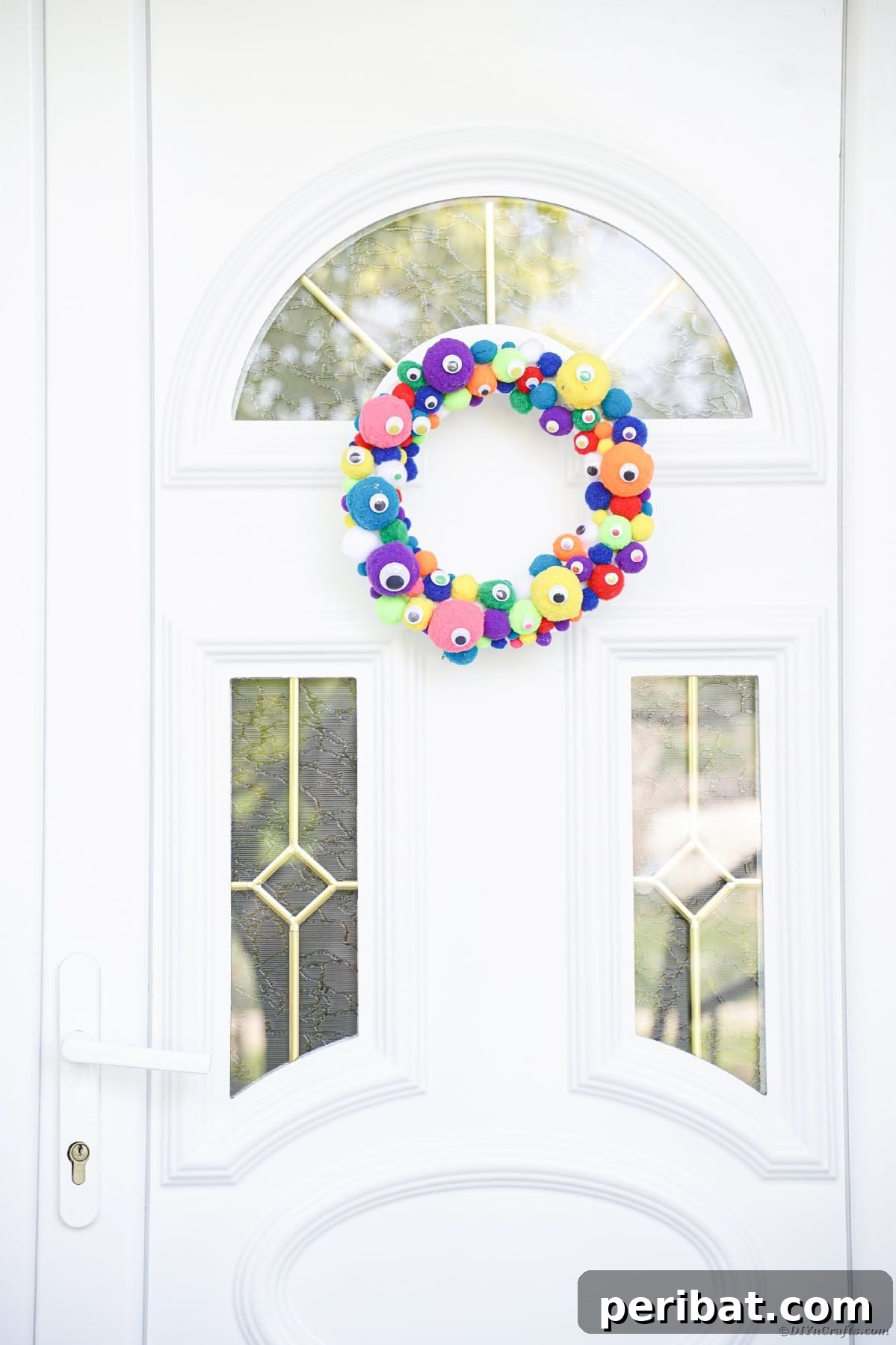 Creepy Cute Pom Pom Monster Wreath 14 Colorful monster eye wreath on white front door