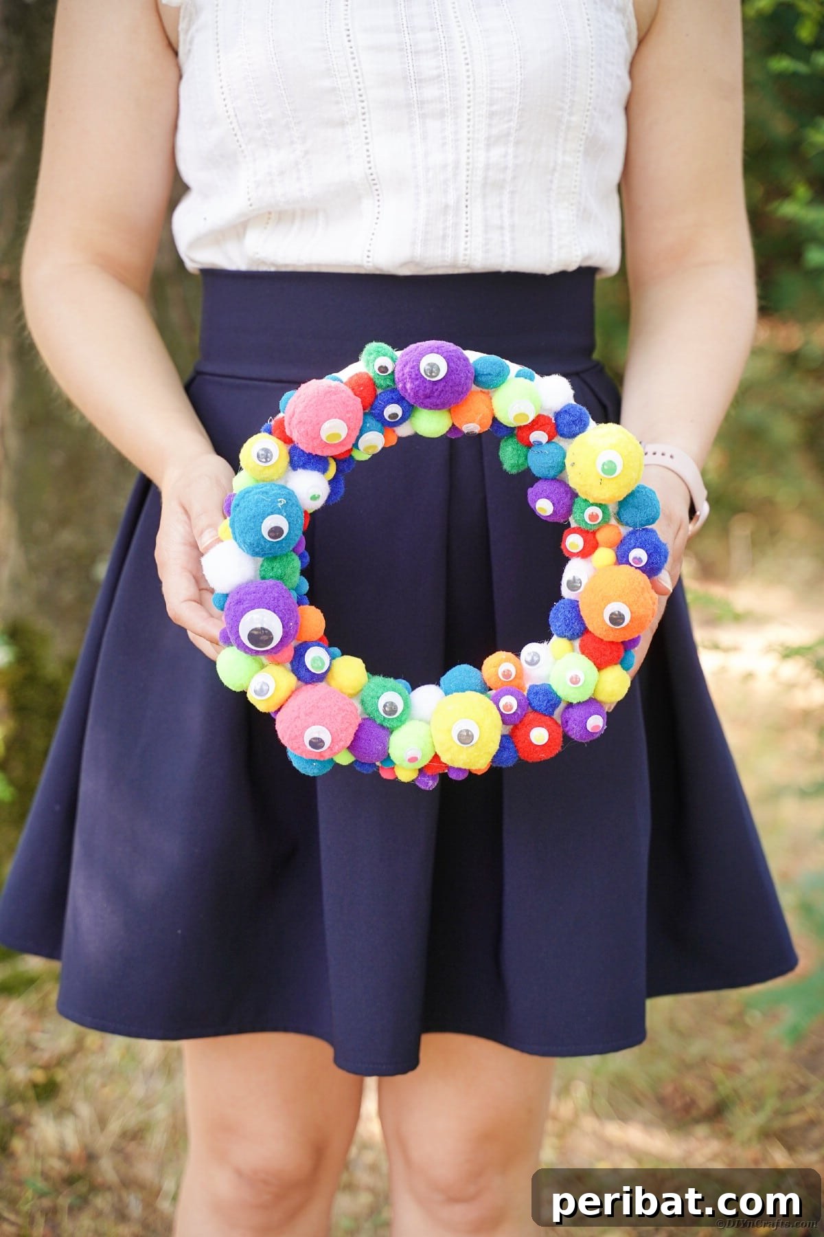 Creepy Cute Pom Pom Monster Wreath 16 Woman holding monster eye wreath