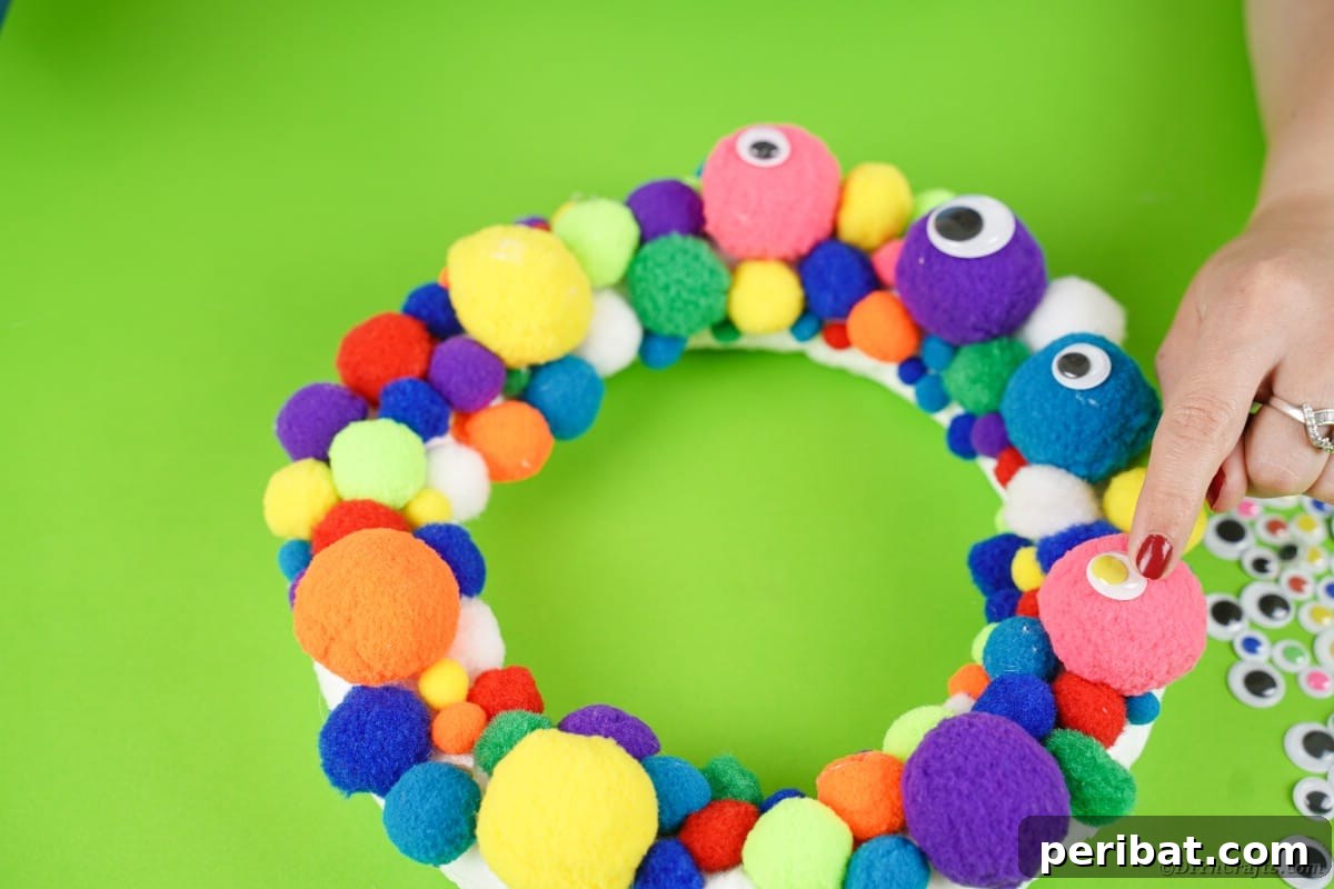 Creepy Cute Pom Pom Monster Wreath 7 Gluing eyes to wreath