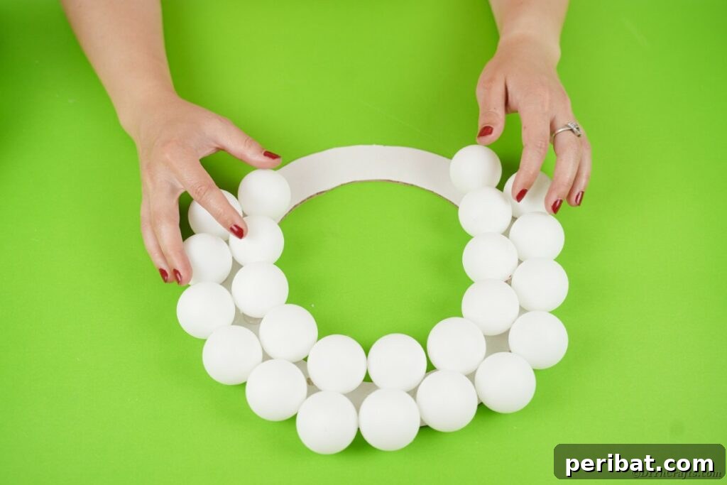 Ghoul's Eye Halloween Entry Wreath 11 A partially completed monster eyeball wreath, showcasing the density of the ping pong balls covering the cardboard base, with a gap at the top