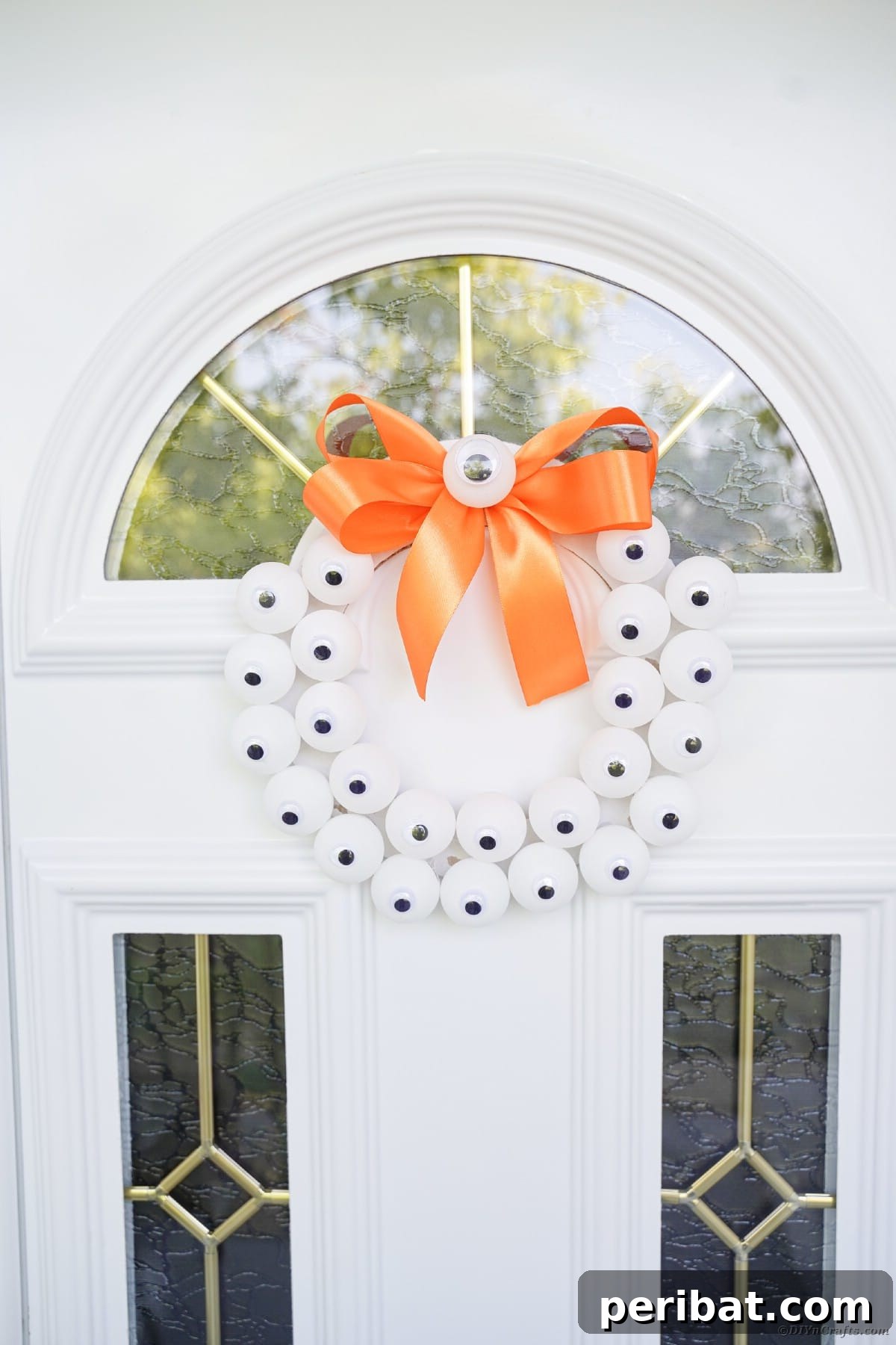 Ghoul's Eye Halloween Entry Wreath 23 Finished eyeball wreath hanging on a white door