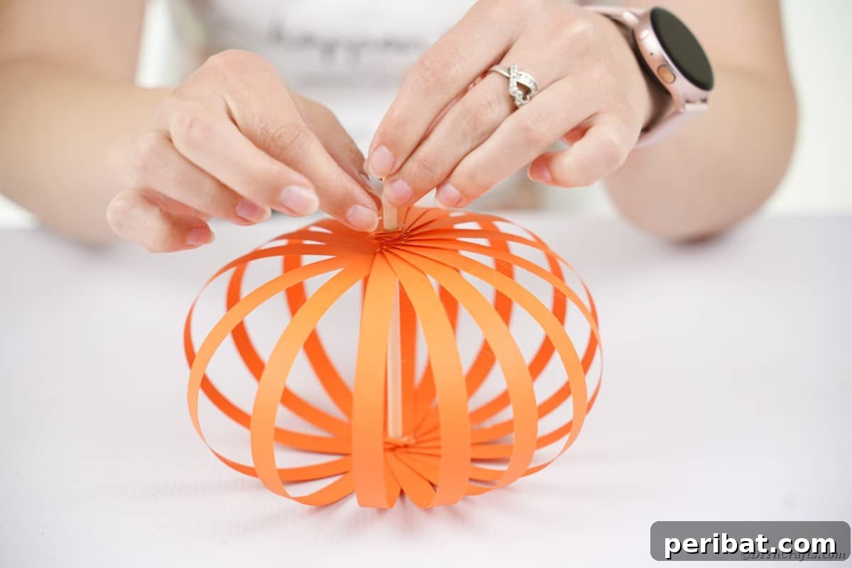 Spooky Paper Strip Creations: Bats, Pumpkins & Spiders 15 All orange paper strips are glued at both ends to the dowel, forming a complete paper pumpkin shape.