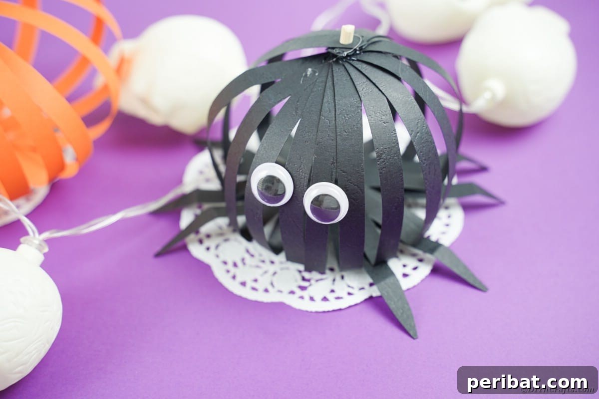 Spooky Paper Strip Creations: Bats, Pumpkins & Spiders 6 A meticulously crafted black paper spider with large googly eyes sits on a delicate white doily, ready for Halloween.