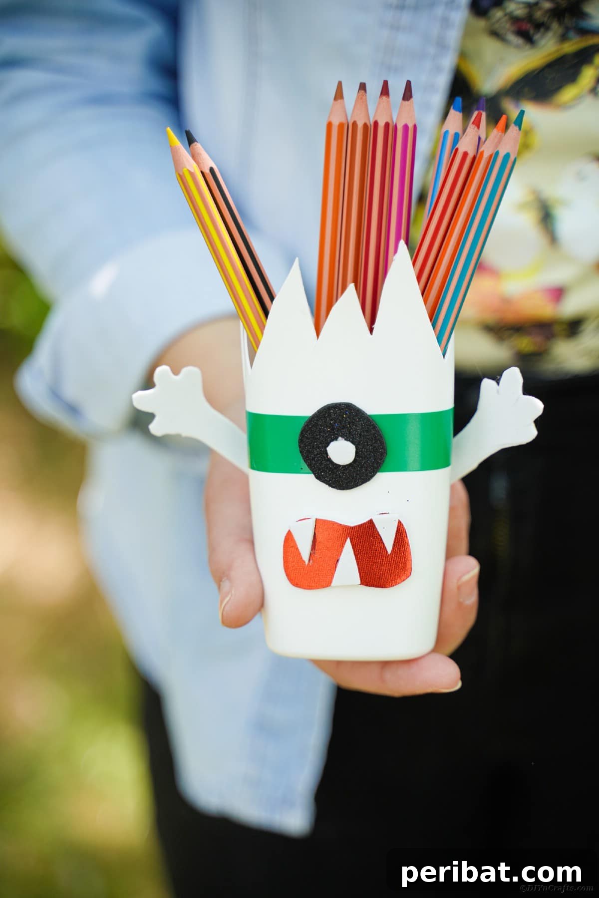 Woman holding monster pencil cans
