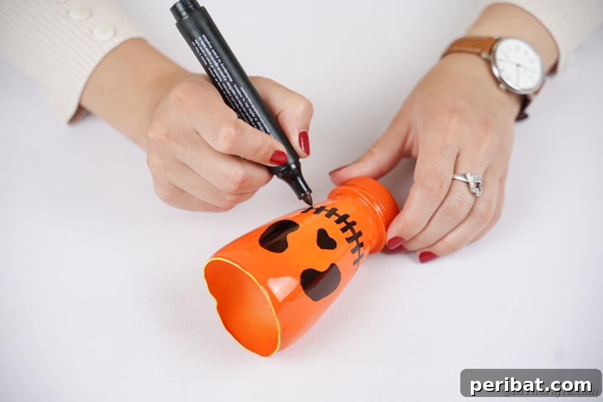 Charming Recycled Bottle Jack O Lantern 11 Drawing a jack-o-lantern face with a black marker on an orange painted bottle