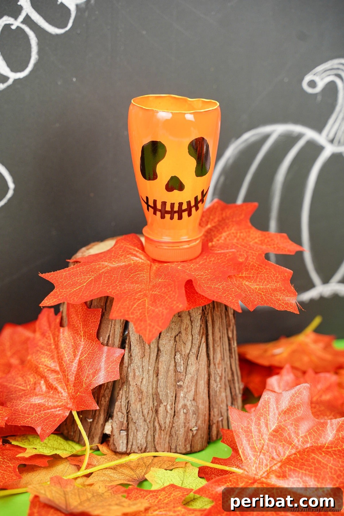 Charming Recycled Bottle Jack O Lantern 13 Finished pumpkin lantern displayed on a desk next to a chalkboard