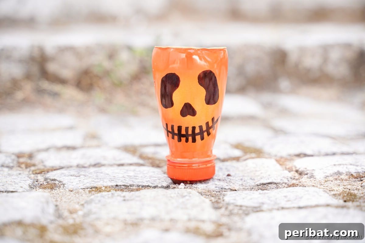 Charming Recycled Bottle Jack O Lantern 4 Pumpkin lantern resting on natural rocks, ready for display