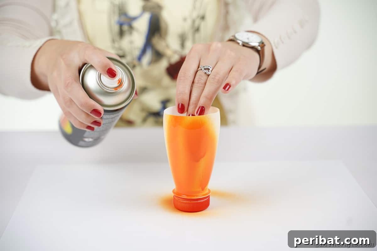 Charming Recycled Bottle Jack O Lantern 9 Hands spray painting a plastic bottle orange