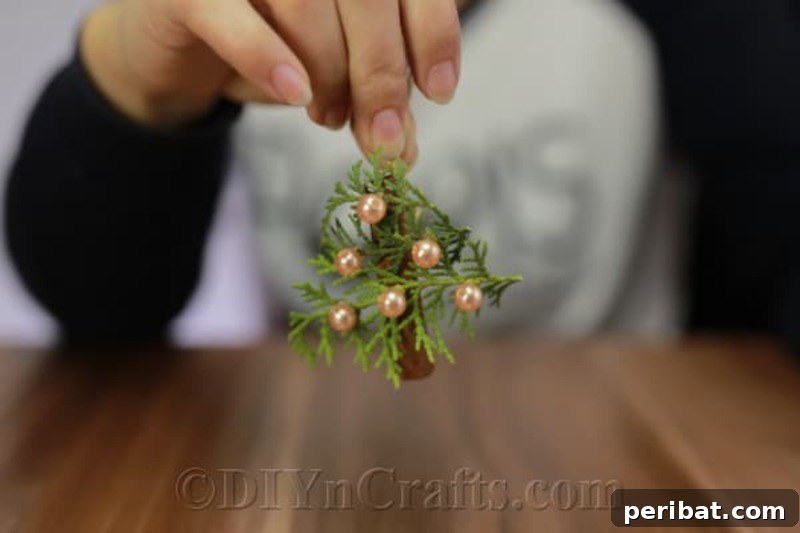40+ Adorable Mini Christmas Tree Decor Ideas 14 Rustic aromatic Christmas tree ornament made from fresh greenery, designed to add beauty and natural scent to your holiday decor.