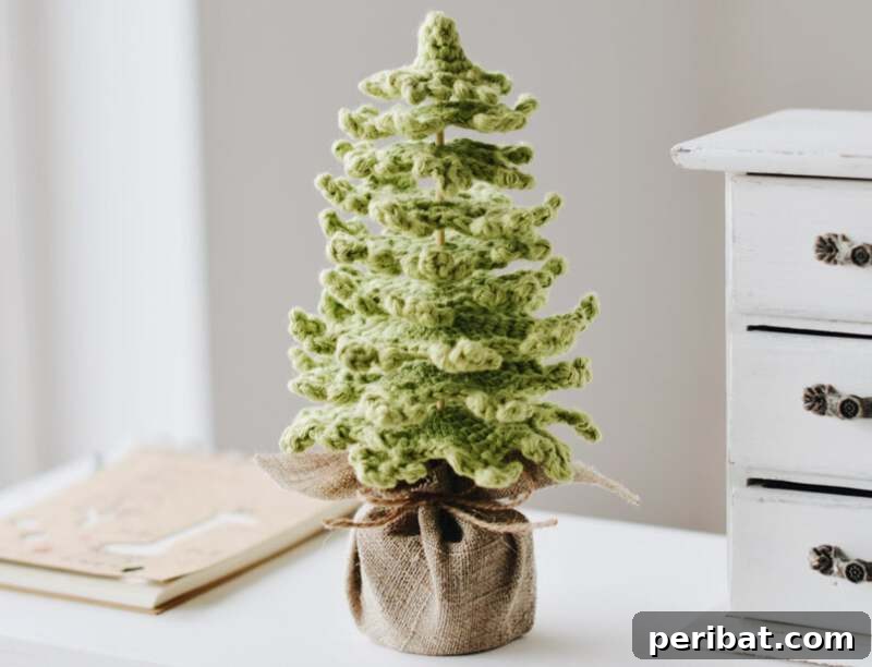 40+ Adorable Mini Christmas Tree Decor Ideas 23 Charming rustic crochet farmhouse Christmas tree in a burlap base, embodying a beloved country-style aesthetic.
