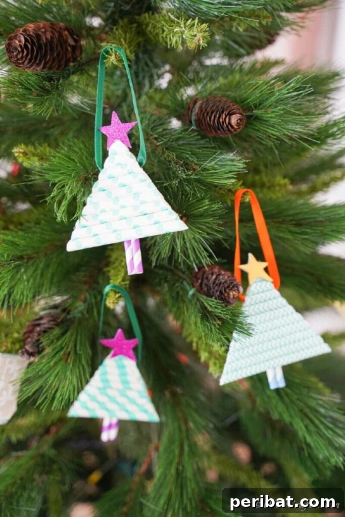 40+ Adorable Mini Christmas Tree Decor Ideas 8 Adorable paper straw Christmas tree ornament hanging from a larger Christmas tree, showcasing a simple and fun craft idea.