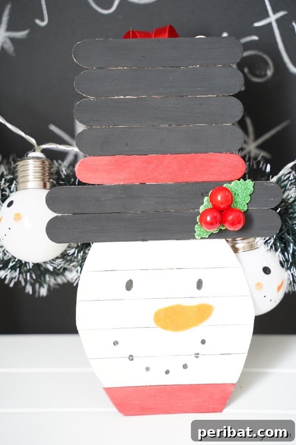 Delightful Christmas Popsicle Stick Creations for Kids 6 Whimsical Craft Stick Snowman Ornament on a Rustic Chalkboard Background