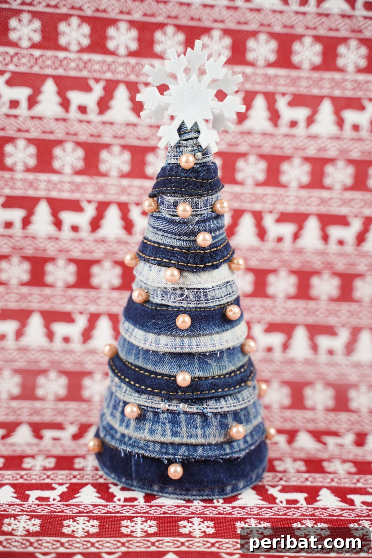 Upcycled Denim Mini Christmas Tree 20 Mini Christmas tree in front of red holiday paper
