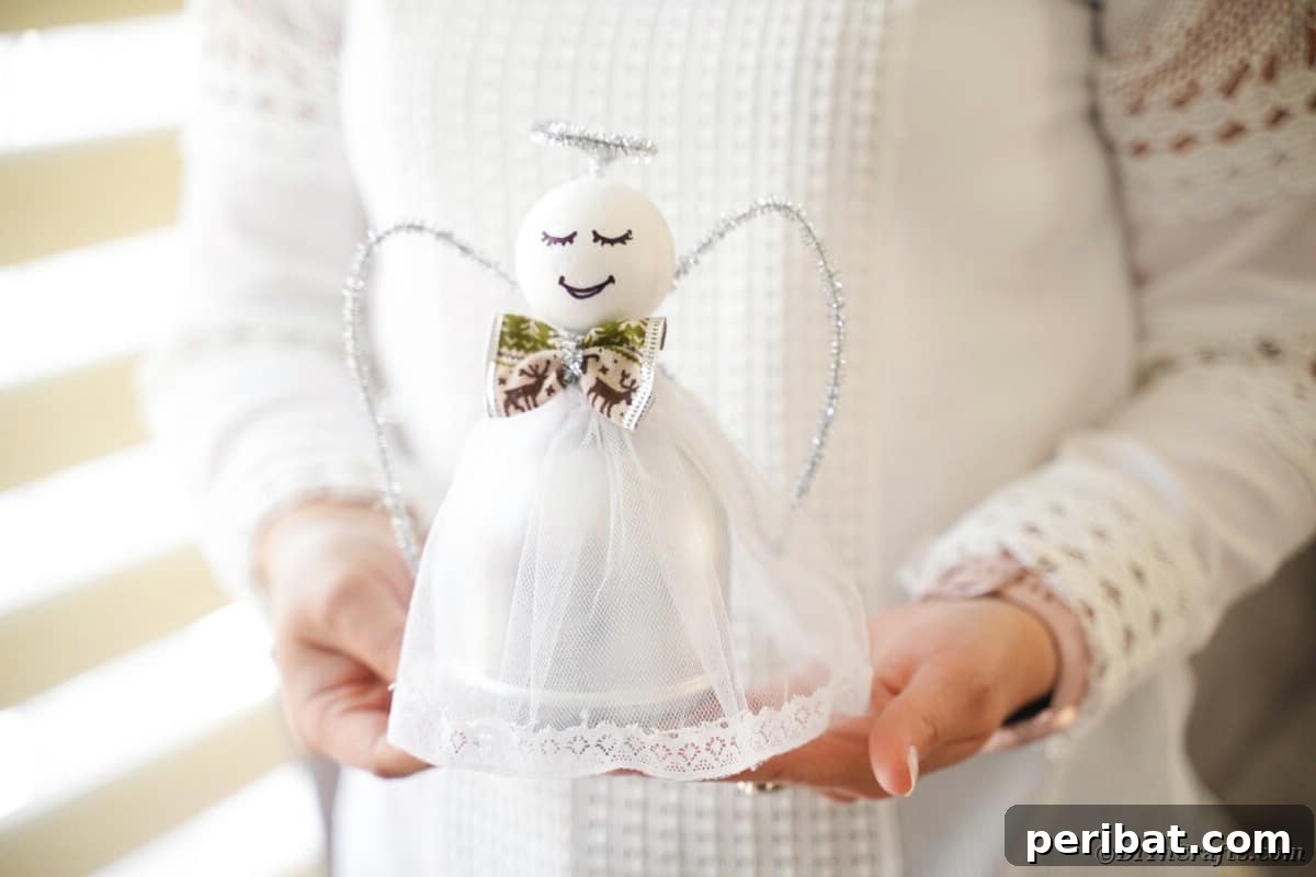 Enchanting Upcycled Bottle Angel Ornament 4 Woman holding upcycled bottle angel, demonstrating the finished look of the Christmas craft.