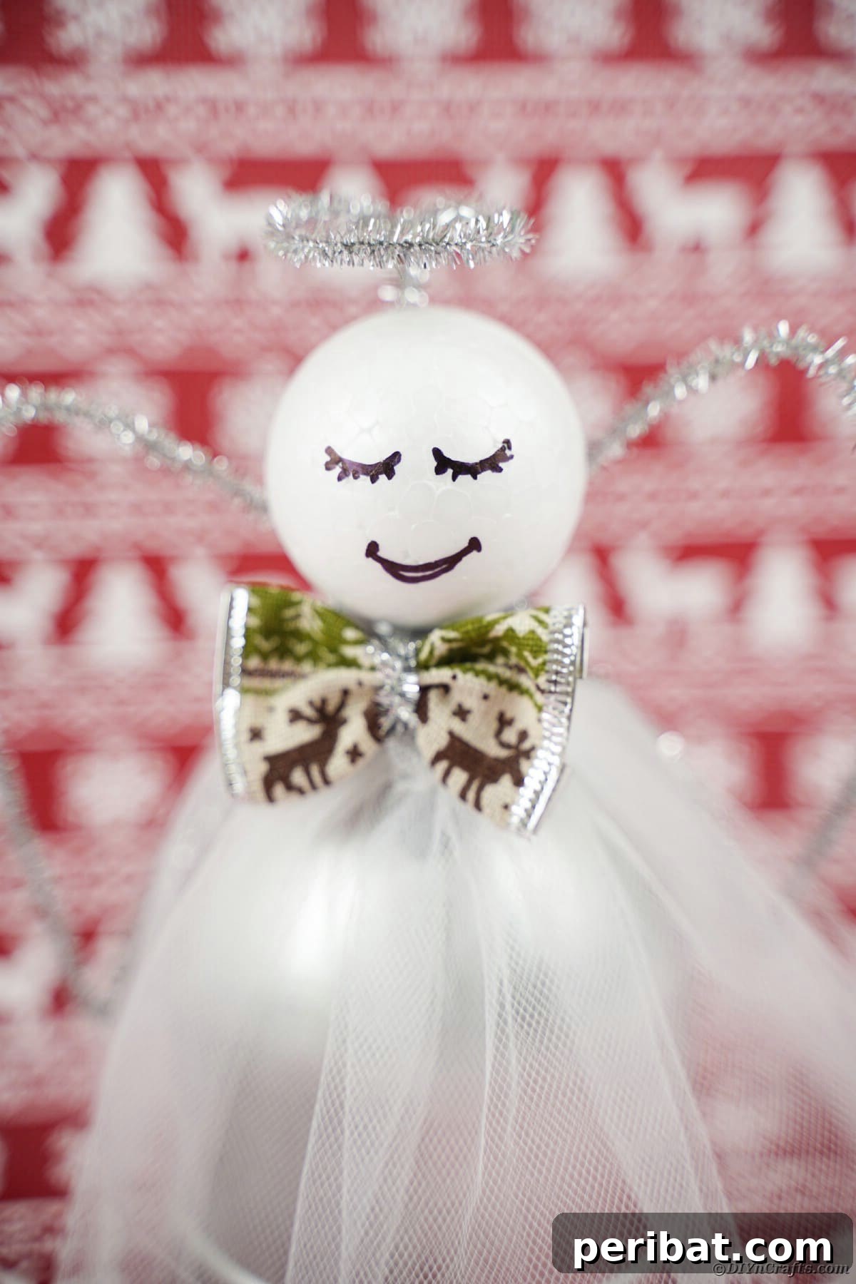 Enchanting Upcycled Bottle Angel Ornament 5 Angel against red reindeer background, showcasing a personalized upcycled bottle angel.