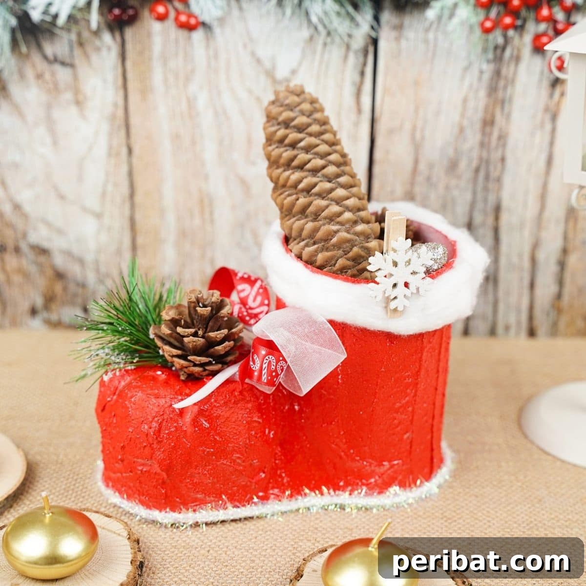 Festive Santa boot crafted from an upcycled plastic bottle, displayed on a wooden surface.