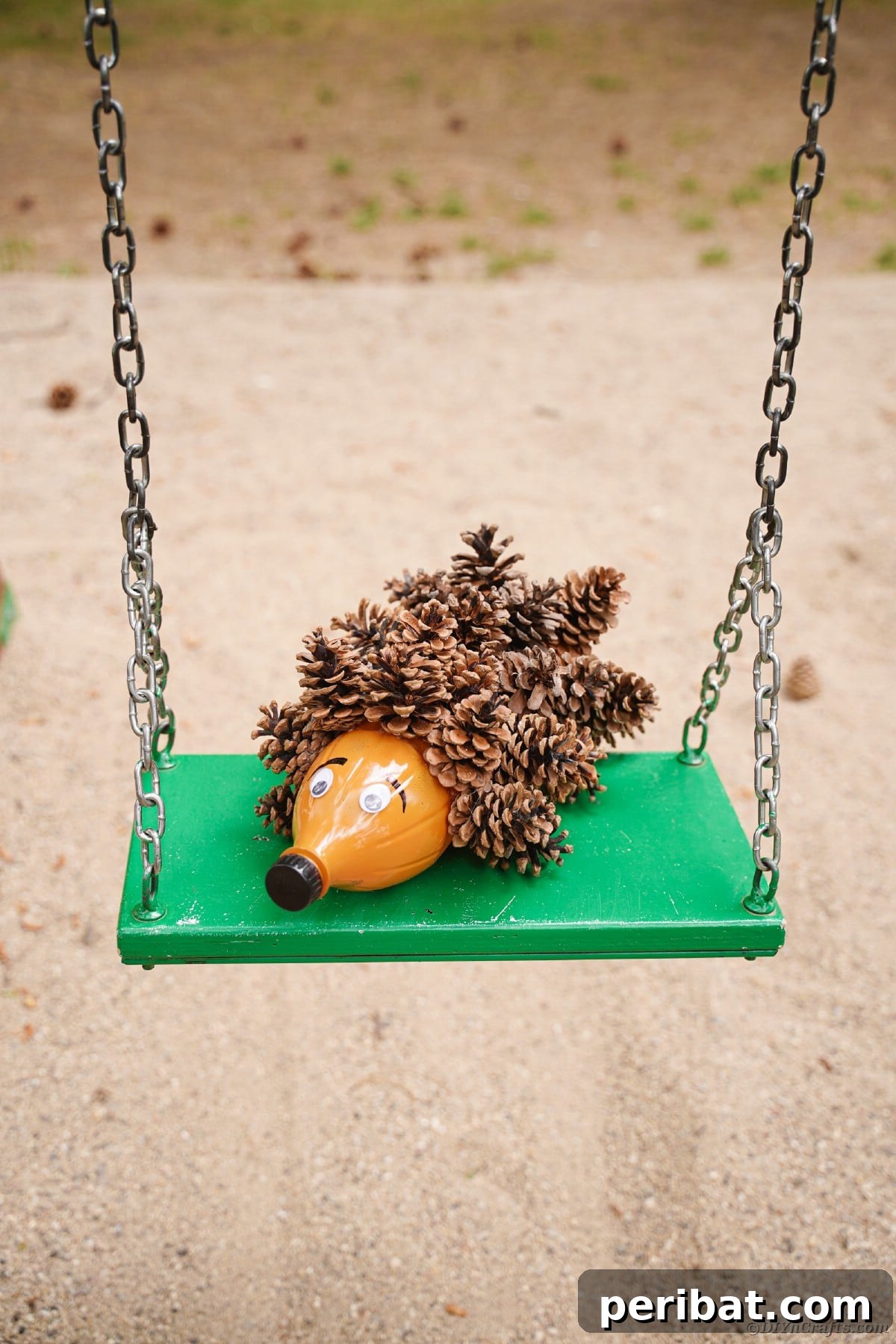 Charming Upcycled Pinecone Hedgehog Art 16 Hedgehog decoration on green swing, showing a unique way to display the craft