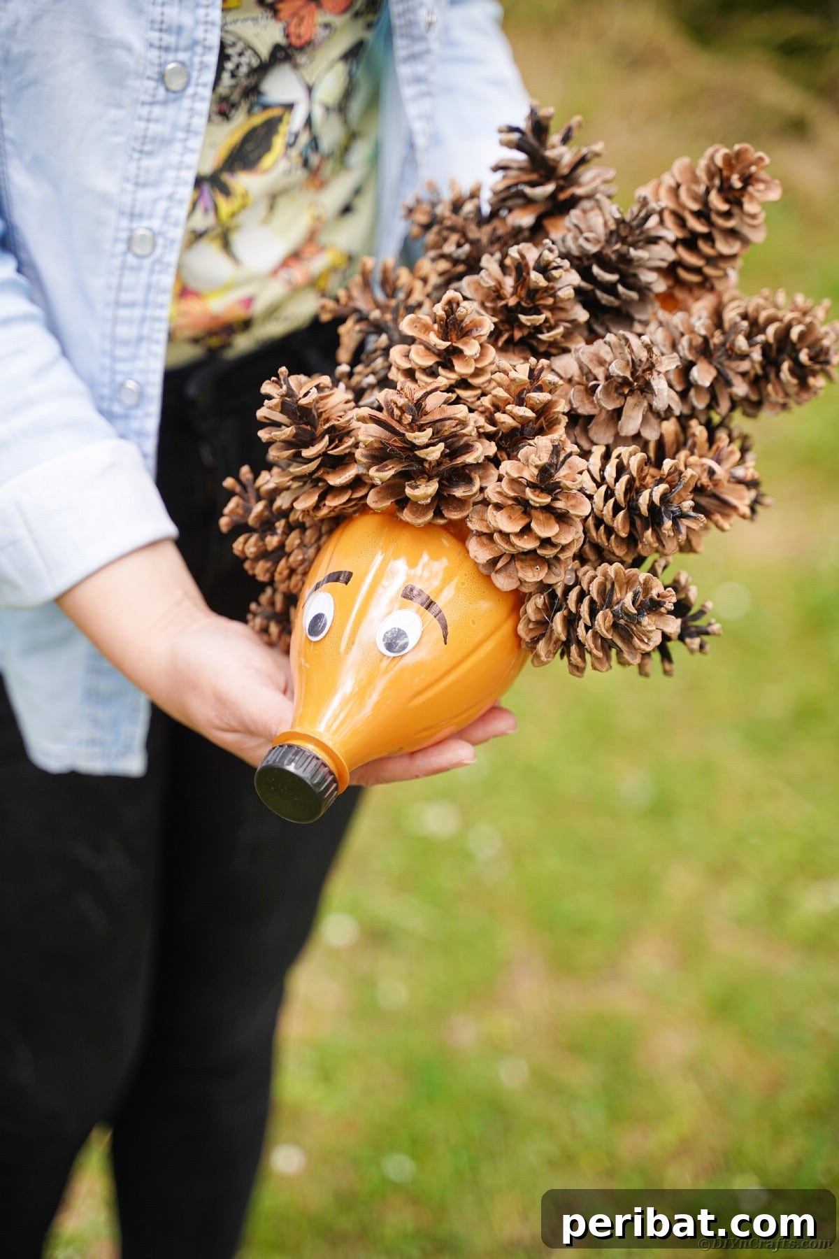 Charming Upcycled Pinecone Hedgehog Art 17 Woman holding a hedgehog made of pinecones, demonstrating its ideal size for display