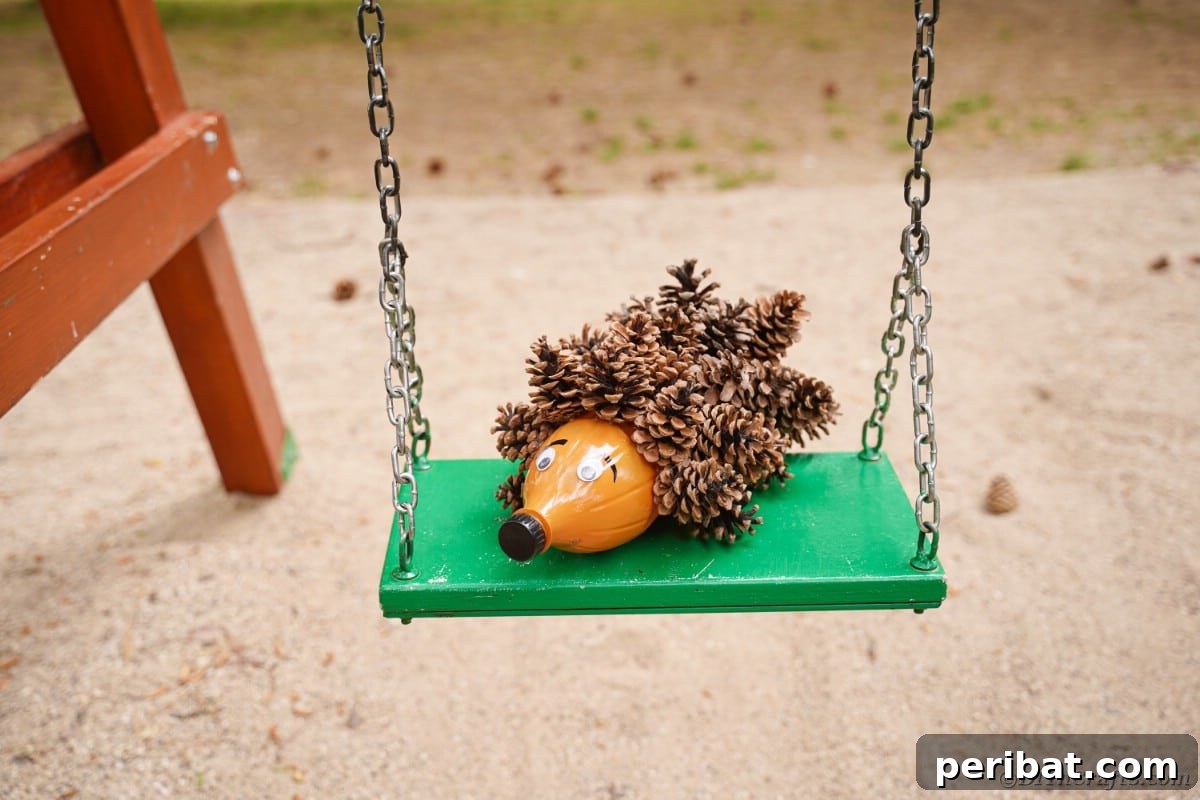 Charming Upcycled Pinecone Hedgehog Art 4 Hedgehog decoration sitting on a green swing, blending rustic charm with outdoor elements