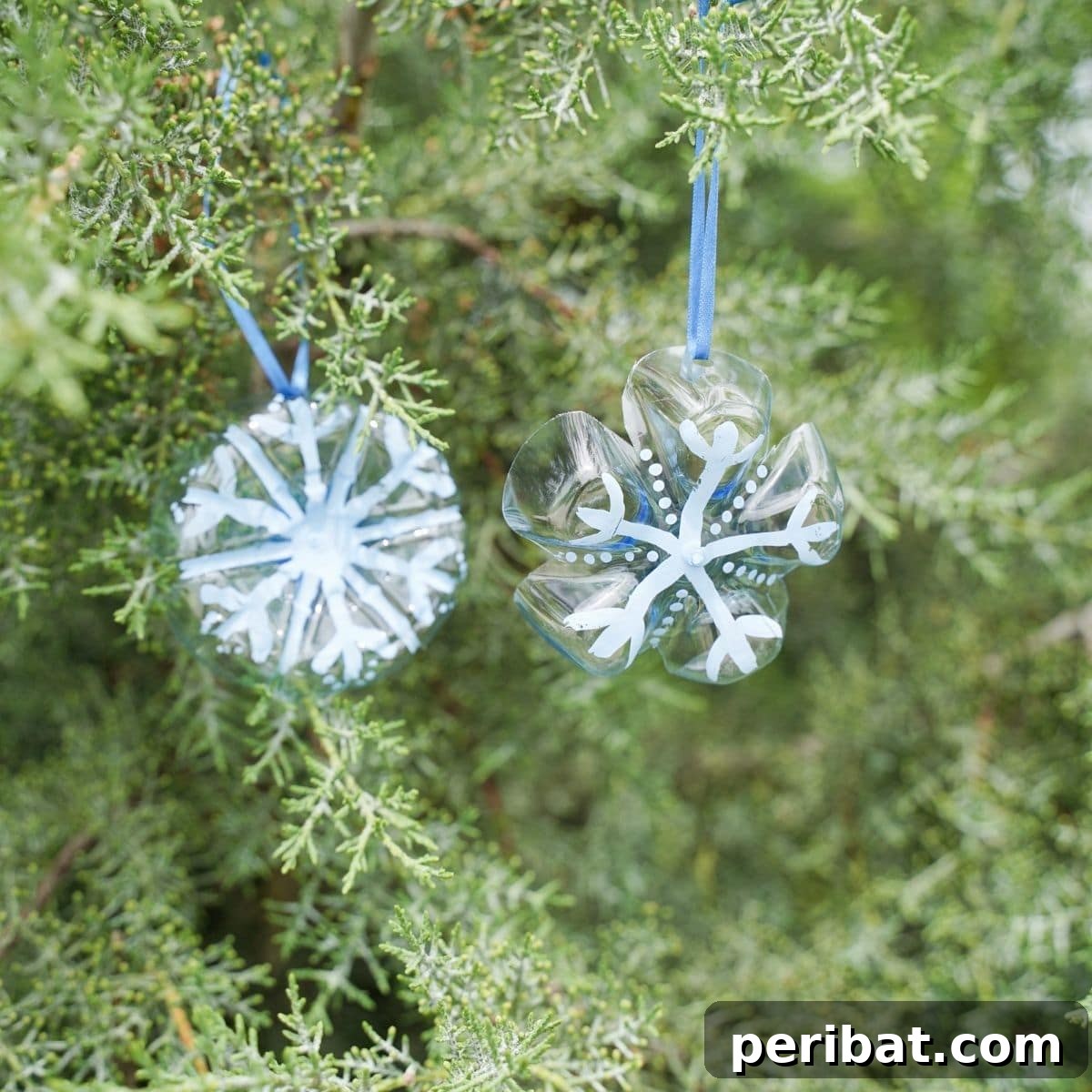 Bottle to Bauble: Stunning Upcycled Snowflakes 2 Snowflake ornaments in evergreen tree