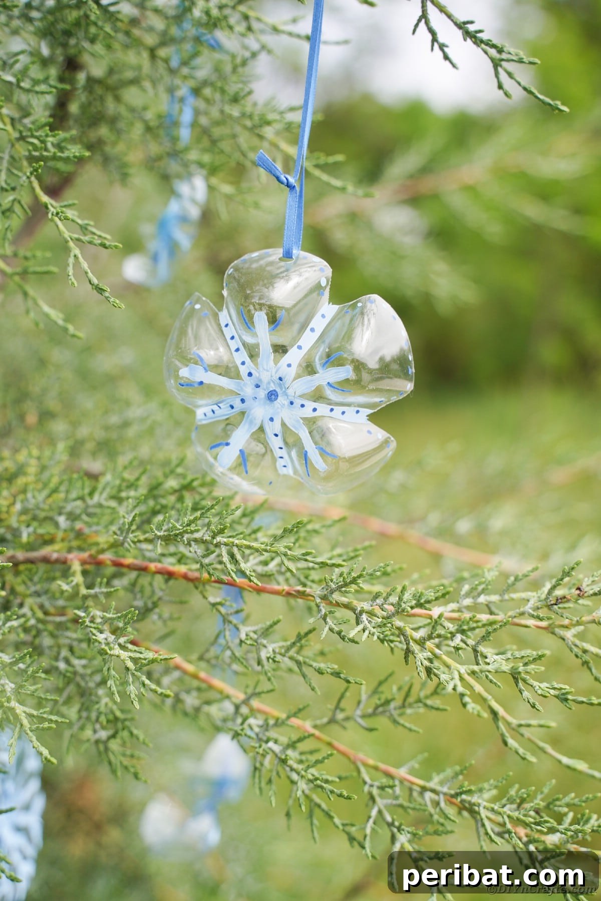 Bottle to Bauble: Stunning Upcycled Snowflakes 16 Snowflake ornaments in evergreen tree