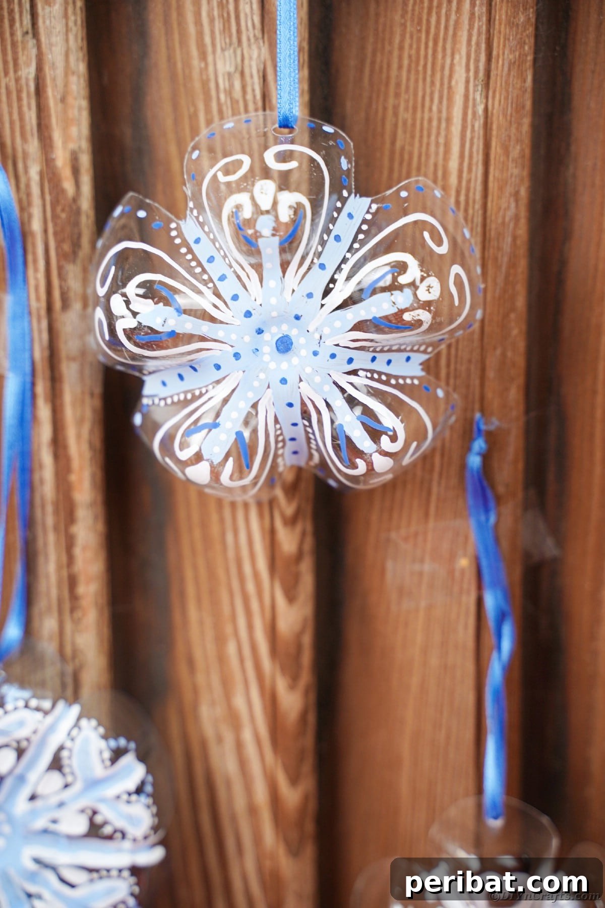 Bottle to Bauble: Stunning Upcycled Snowflakes 18 Snowflake ornaments on wooden wall