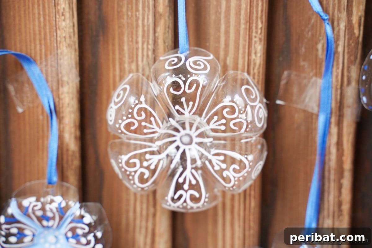Bottle to Bauble: Stunning Upcycled Snowflakes 4 Snowflake ornaments on wooden wall