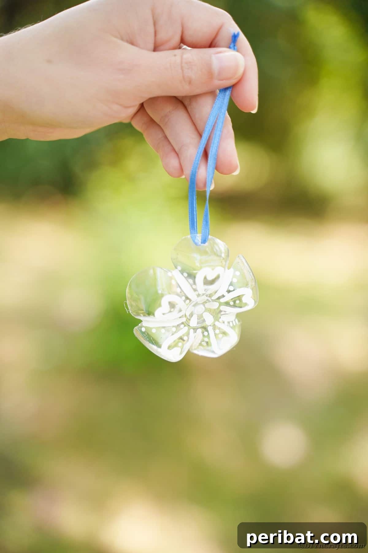 Bottle to Bauble: Stunning Upcycled Snowflakes 20 Hand holding snowflake ornament