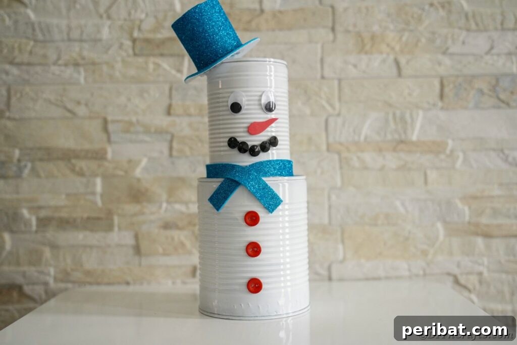 DIY Painted Tin Can Snowman Video Tutorial 3 A charming tin can snowman displayed against a rustic brick wall, highlighting its versatile aesthetic.