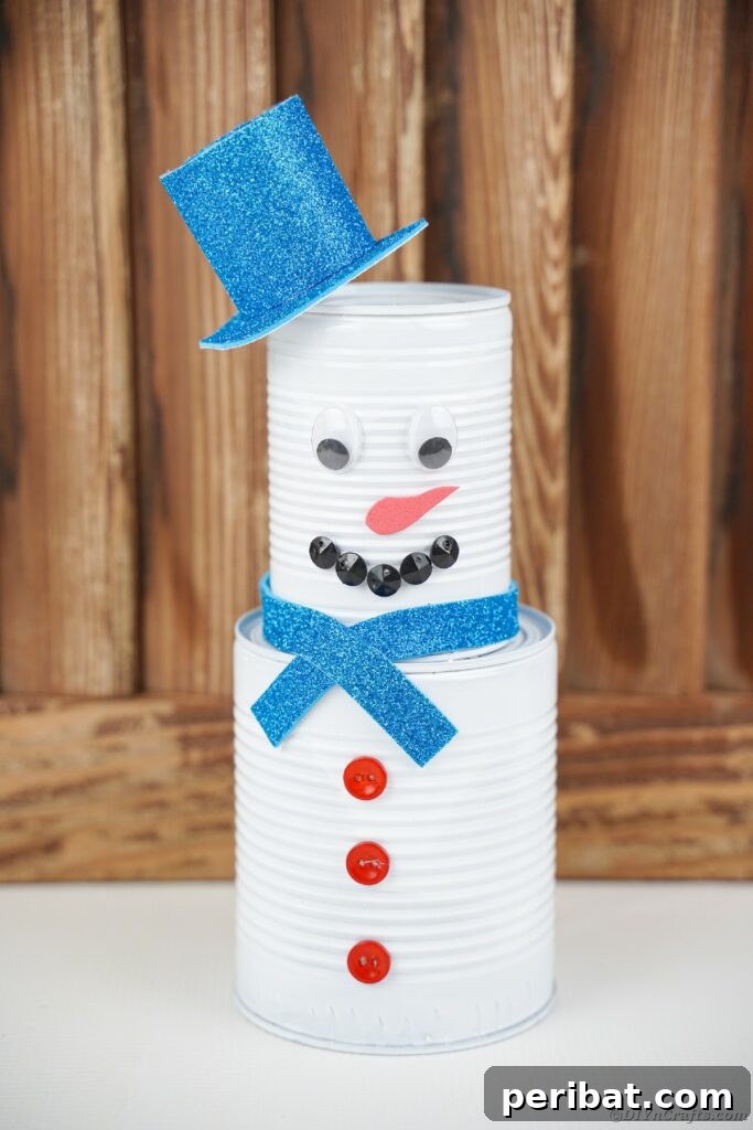 DIY Painted Tin Can Snowman Video Tutorial 28 A charming tin can snowman displayed against a warm wooden wall, illustrating customization possibilities.