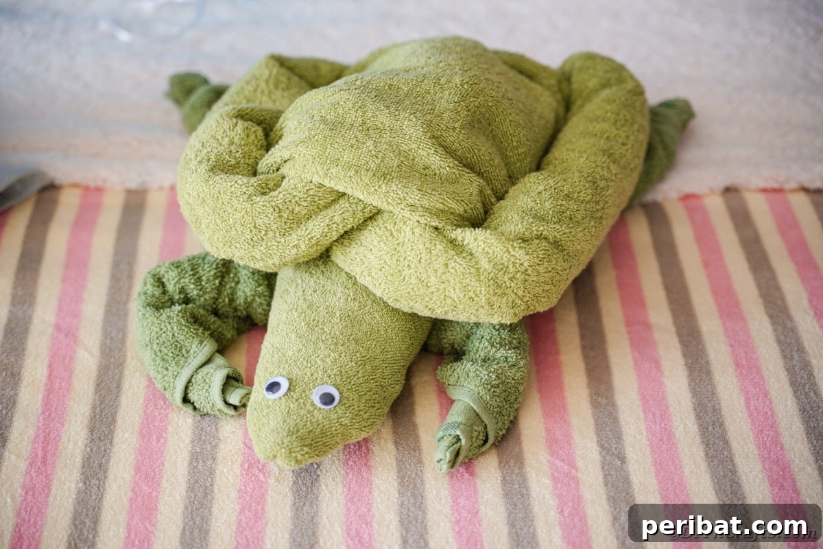 Towel Origami: Animal Edition 3 Green towel folded into a cute turtle shape on a bed
