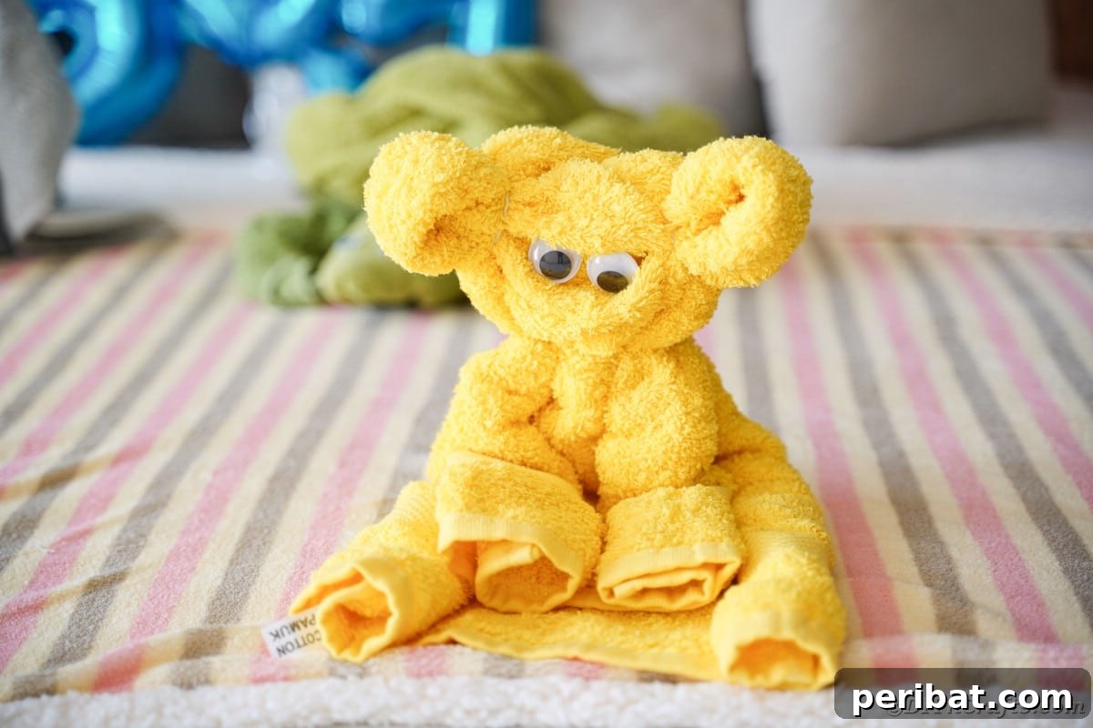 Towel Origami: Animal Edition 4 Yellow towel folded into a friendly bear shape on a bed