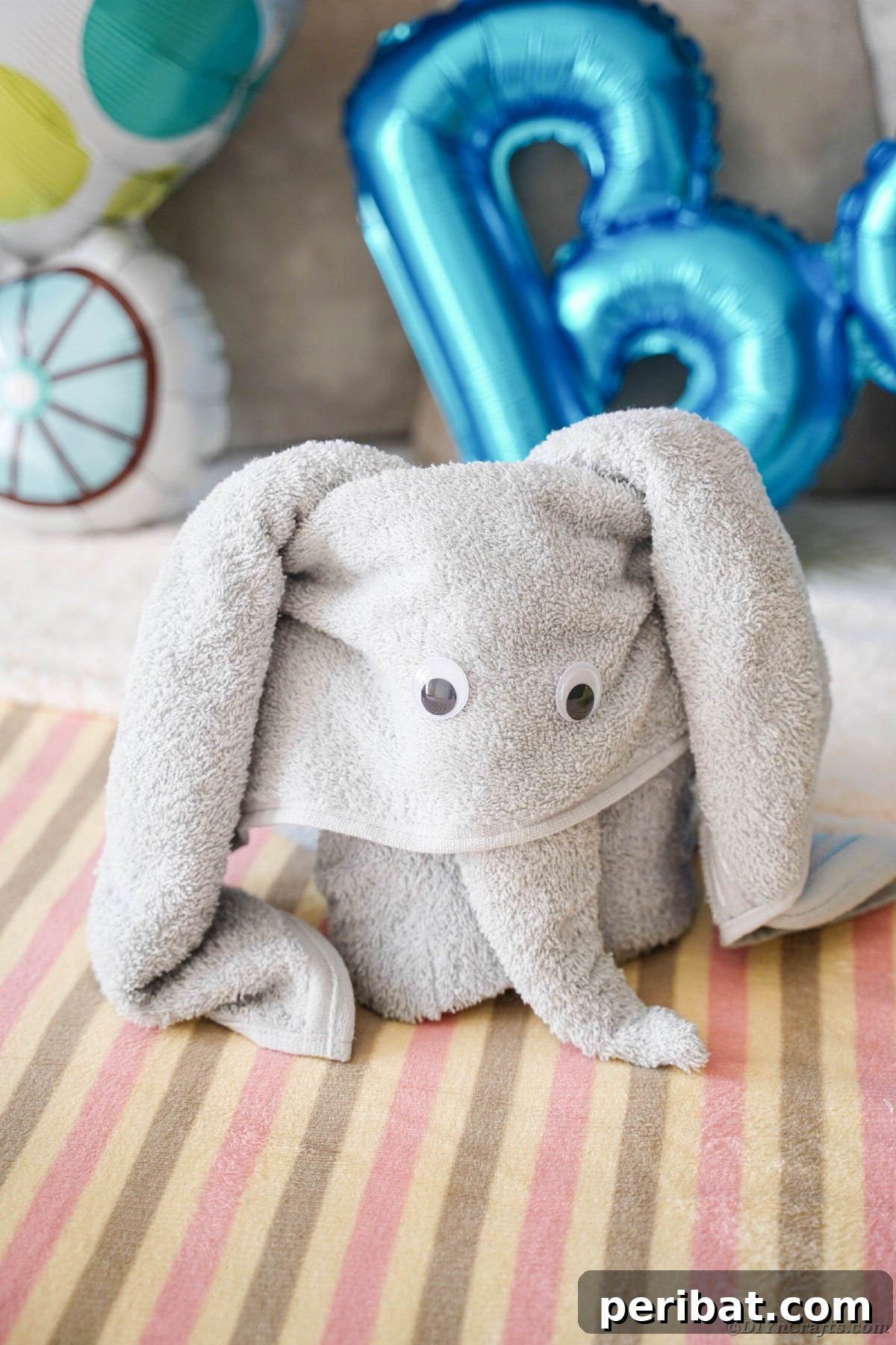 Towel Origami: Animal Edition 5 Grey towel folded into an elegant elephant shape on a bed