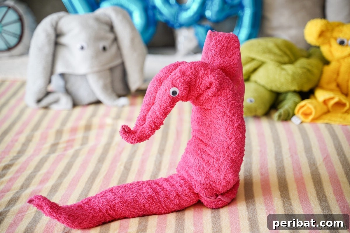 Towel Origami: Animal Edition 6 Pink towel folded into a whimsical seahorse shape on a bed